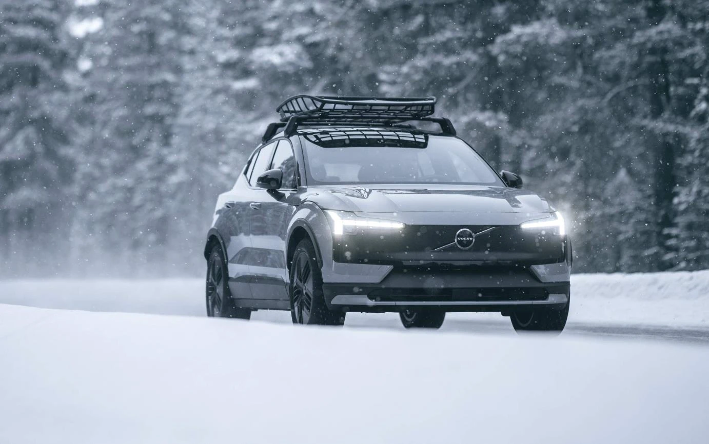 Volvo EX30 Cross Country cinza em uma estrada coberta de neve.